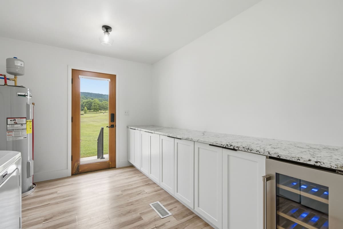 Mudroom with a long stone counter and a glass door opening straight onto the fairway.